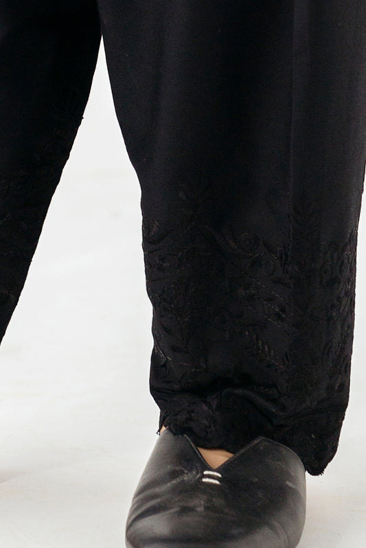 "Chic black trousers with intricate embroidery along the border
